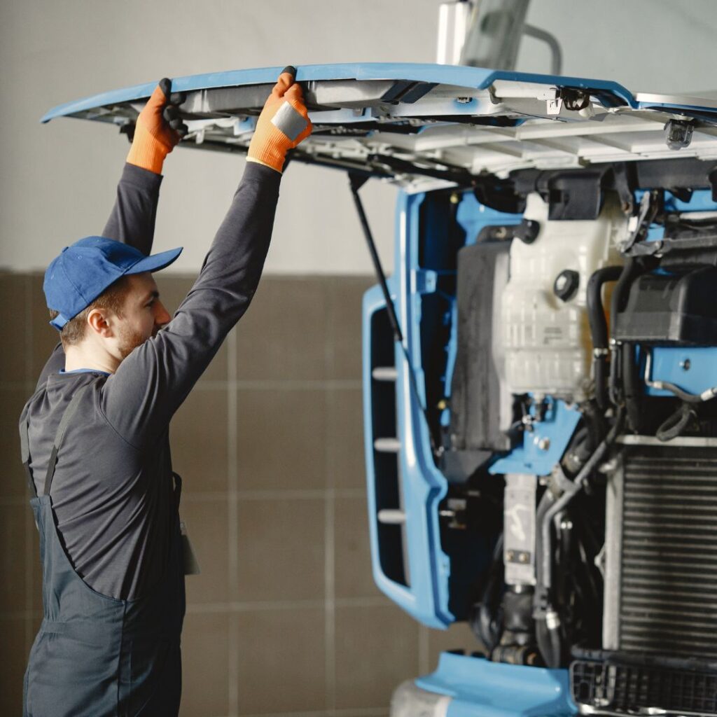 a professional looking at a semi truck engine